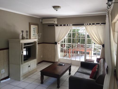a living room with a couch and a table at Summerview Guest Lodge in Johannesburg