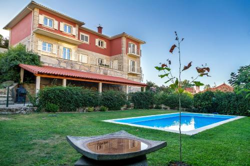 a large house with a swimming pool in the yard at Casa da Oliveira in Mondim de Basto