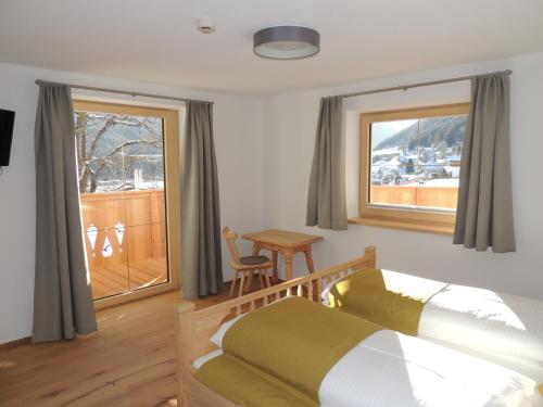 a bedroom with a bed and a window and a table at Buttererhof-Apartments in Fulpmes