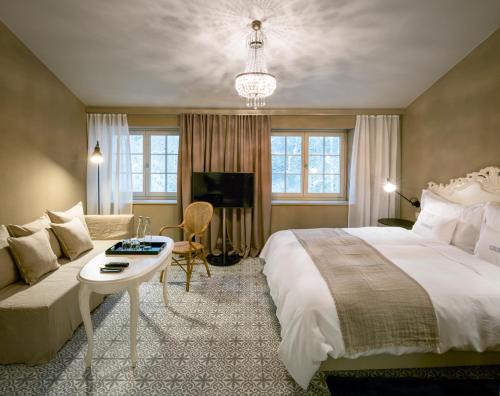 Una habitación de hotel con una cama grande y un sofá. en La Couronne Atelier - Dependance, en Solothurn