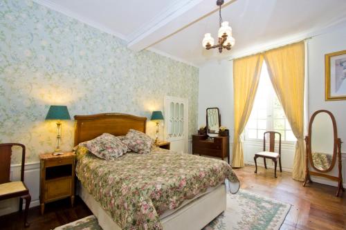 um quarto com uma cama, uma mesa e um espelho em Chateau de Fayolle em Ribérac