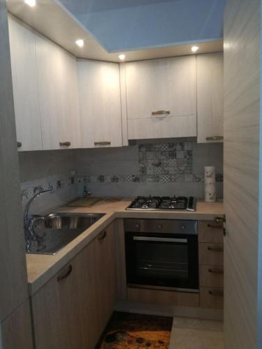 a kitchen with white cabinets and a sink at Casa Vacanze LIBERTY in Licata