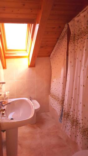 a bathroom with a sink and a toilet and a window at Casa Joan in Barruera