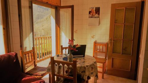 a room with a table with a laptop on a balcony at Casa Joan in Barruera