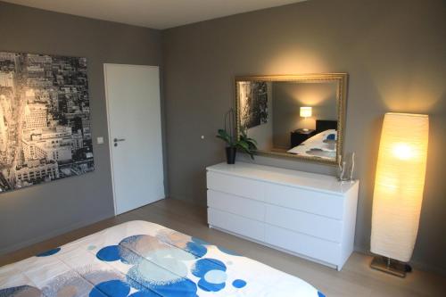a bedroom with a bed and a mirror on a dresser at NEW Design apartment in Brussels in Brussels