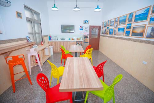 a room with tables and colorful chairs in a restaurant at Colorful B&B in Xiaoliuqiu