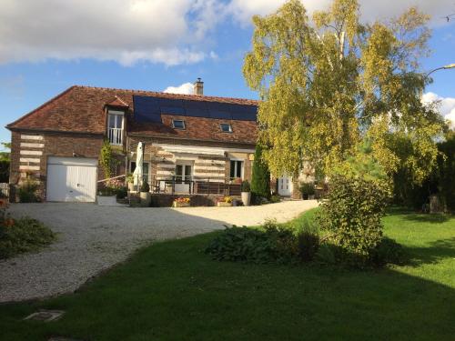 a brick house with a garage and a driveway at La longère Champenoise in Prugny