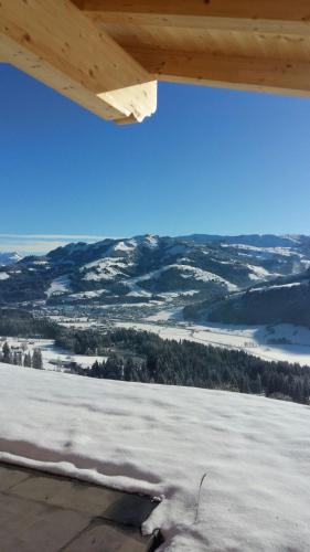 a view of a snow covered field from the wing of an airplane at Reiterbauer Chalets & Ferienwohnungen in Kirchberg in Tirol