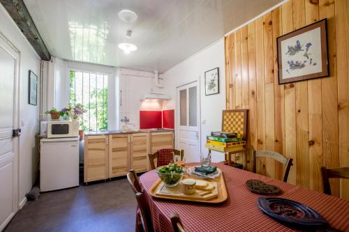 une cuisine et une salle à manger avec une table et des chaises dans l'établissement La Maison de L'Ousse, à Livron