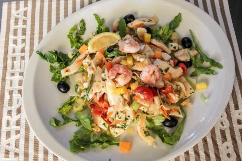 a white plate with a salad with shrimp and vegetables at Hotel Riziana in Cervia