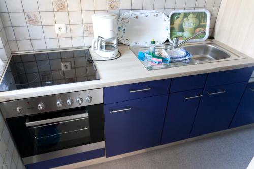 a kitchen counter with a sink and a stove at Appartmenthaus Kehrwieder in Sankt Peter-Ording