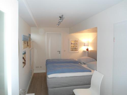 niewielka sypialnia z łóżkiem i krzesłem w obiekcie Ferienwohnung Likedeeler w mieście Wyk auf Föhr