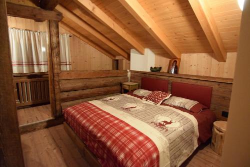 a bedroom with a bed in a room with wooden ceilings at Tobià Gries in Canazei