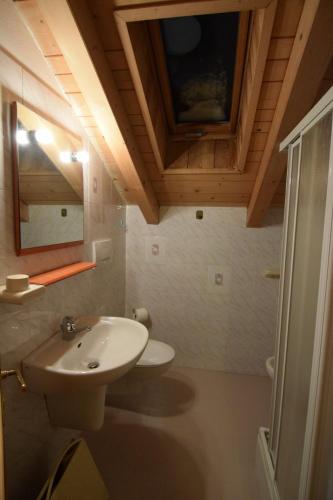 a bathroom with a white sink and a mirror at Tobià Gries in Canazei