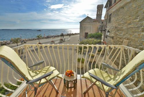 a balcony with two chairs and a view of the ocean at Apartments Maja in Piran