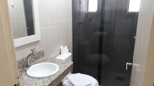 a bathroom with a shower and a sink and a toilet at Pousada Cheiro De Mar in Imbituba