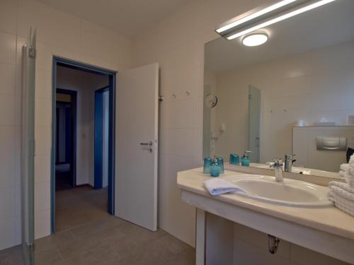 a bathroom with a sink and a large mirror at Hotel Friesische Wehde in Bockhorn