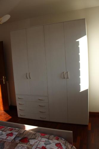 a bedroom with two white cabinets and a bed at Boccaor in Paderno del Grappa