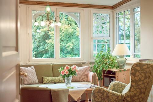 a living room with a table with a vase of flowers at Pension Villa Edelweiß in Ostseebad Sellin
