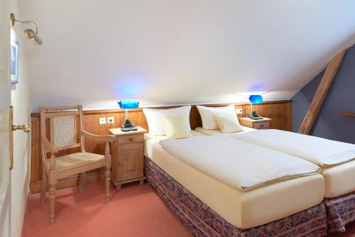 a bedroom with a bed and a desk and a chair at Pension Villa Edelweiß in Ostseebad Sellin