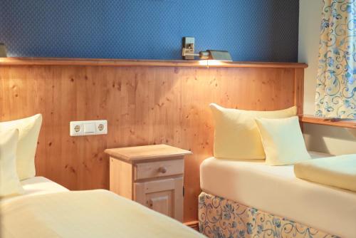 a small room with two beds and a table at Pension Villa Edelweiß in Ostseebad Sellin