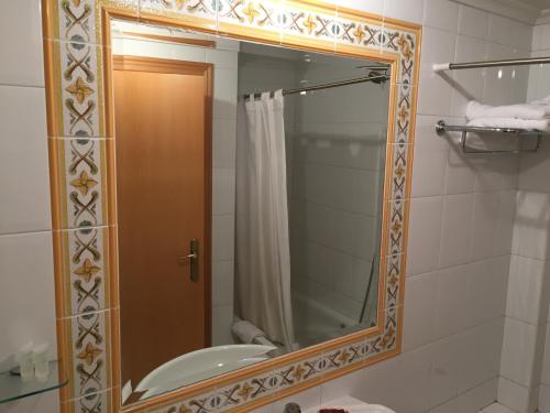 a bathroom with a mirror and a sink at Hotel Los Angeles in La Ba&ntilde;eza