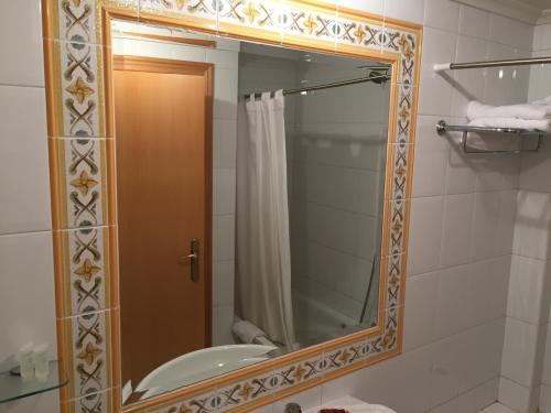 a bathroom with a mirror and a sink at Hotel Los Angeles in La Bañeza