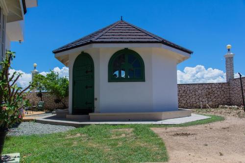 a small building with a green door in a yard at El Cielo in Portmore