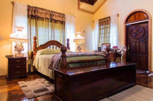 sypialnia z łóżkiem, komodą i stołem w obiekcie El Cielo w mieście Portmore