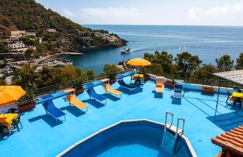 a swimming pool with chairs and a view of the ocean at Le Terrazze sul mare in Ustica