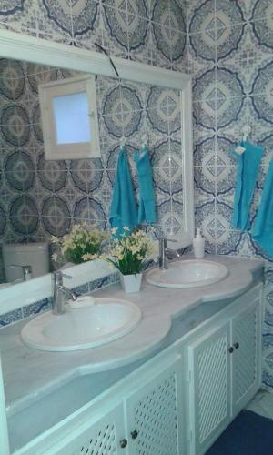 a bathroom with two sinks and a mirror at Dar Ezzahra in Tozeur