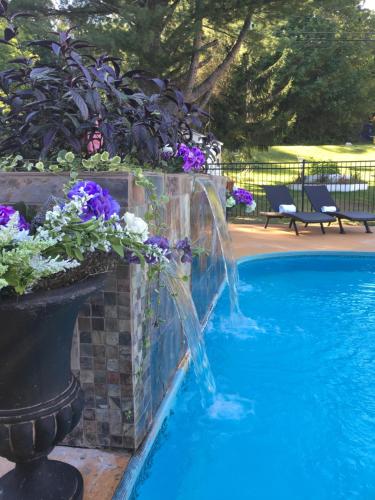 a swimming pool with a fountain in a garden at The Villas on Lake George in Diamond Point