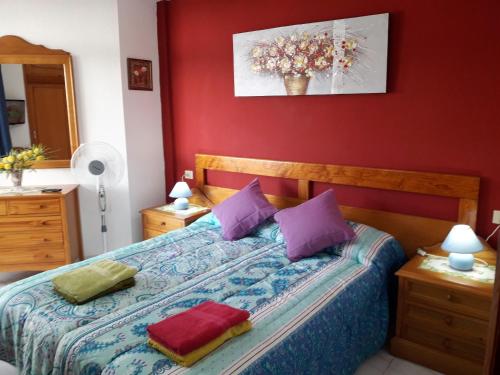 ロス・クリスティアーノスにあるSummerland LC Holiday Homeのベッドルーム(紫色の枕が付くベッド付)