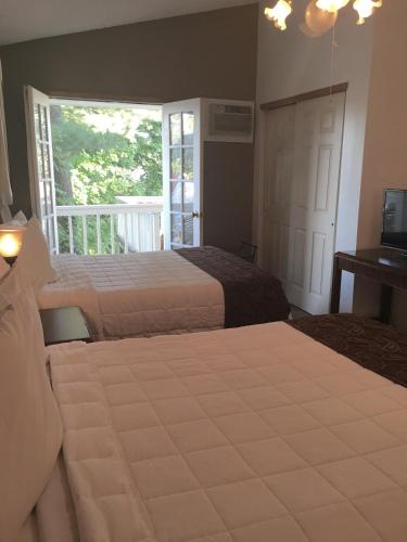 a bedroom with two beds and a window and a television at The Villas on Lake George in Diamond Point