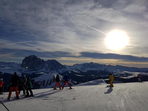 un gruppo di persone che sciano su una montagna innevata di Villa Martha Vintage Hotel-B&B a Santa Cristina in Val Gardena