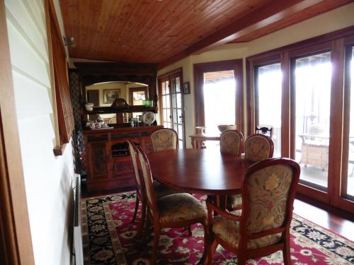 a dining room with a wooden table and chairs at The Old School Bed and Breakfast in Wolumla South