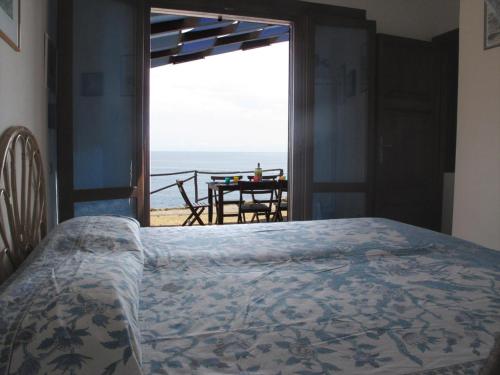 una camera da letto con un letto e vista sull'oceano di Isola d'Elba Come in Barca, a un Tuffo dal Mare a Capoliveri
