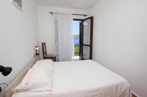 um quarto branco com uma cama e uma janela em Apartment Lile em Kuciste
