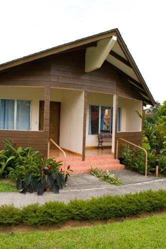 a house with a front porch and some plants at Hotel Eco Arenal in Fortuna