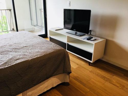 a bedroom with a bed and a television on a dresser at Studio in Belén de Escobar