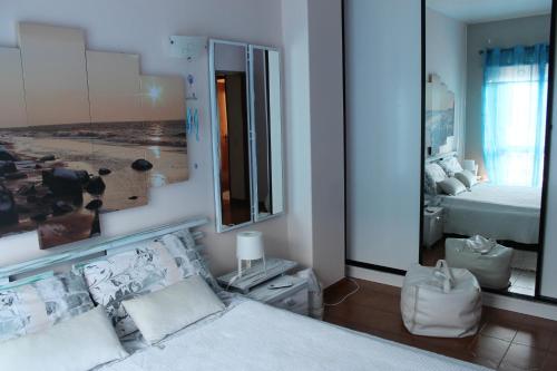 sypialnia z łóżkiem i dużym lustrem w obiekcie Casa Encosta do Sol w Lagosie