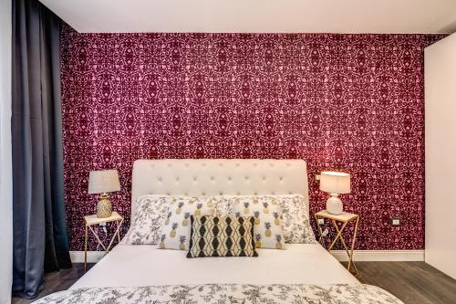 ピサにあるAwesHomeItaly - Hanging Gardensの赤い壁のベッドルーム1室