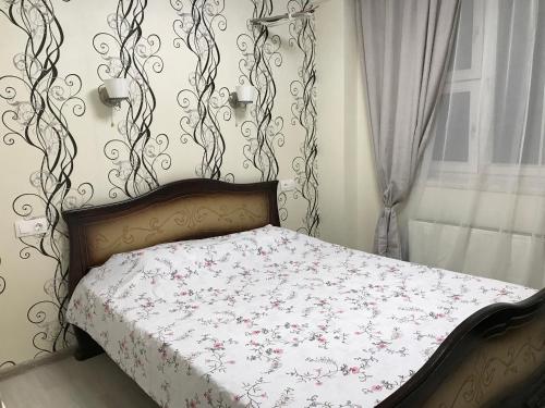 モスクワにあるAdmiral Hotelのベッドルーム1室(花柄のベッドカバー付)