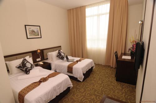 Cette chambre comprend deux lits et une télévision. dans l'établissement Seemsoon Hotel, à Ipoh