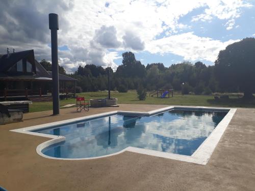 uma piscina num quintal com parque infantil em Martina Bungalows em Ensenada