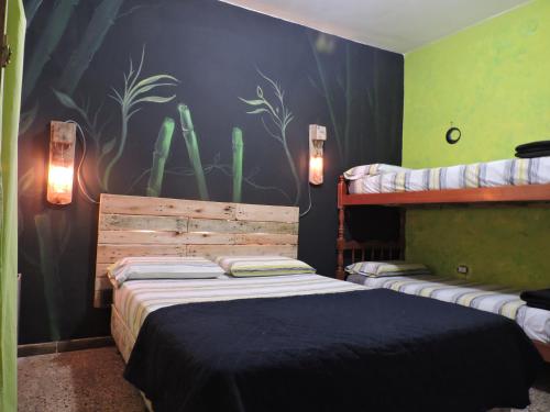 1 dormitorio con 2 camas y una pintura de cactus en Carrusel Art-Hostel en Mar del Plata