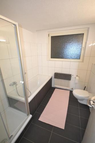 a bathroom with a tub and a toilet and a shower at Madame Tower in Cologne