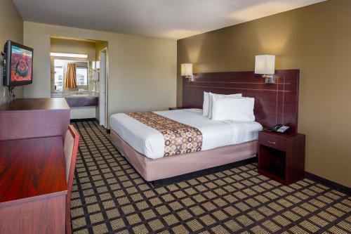 a hotel room with a bed and a bathroom at Travelers Inn - Phoenix in Phoenix
