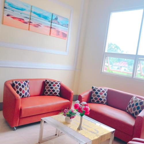 a living room with two red couches and a table at Revayah Hotels in Ruteng