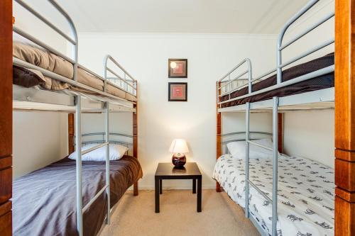 2 Etagenbetten in einem Zimmer mit einem Tisch und einer Lampe in der Unterkunft Casa Dolce Casa in Rye